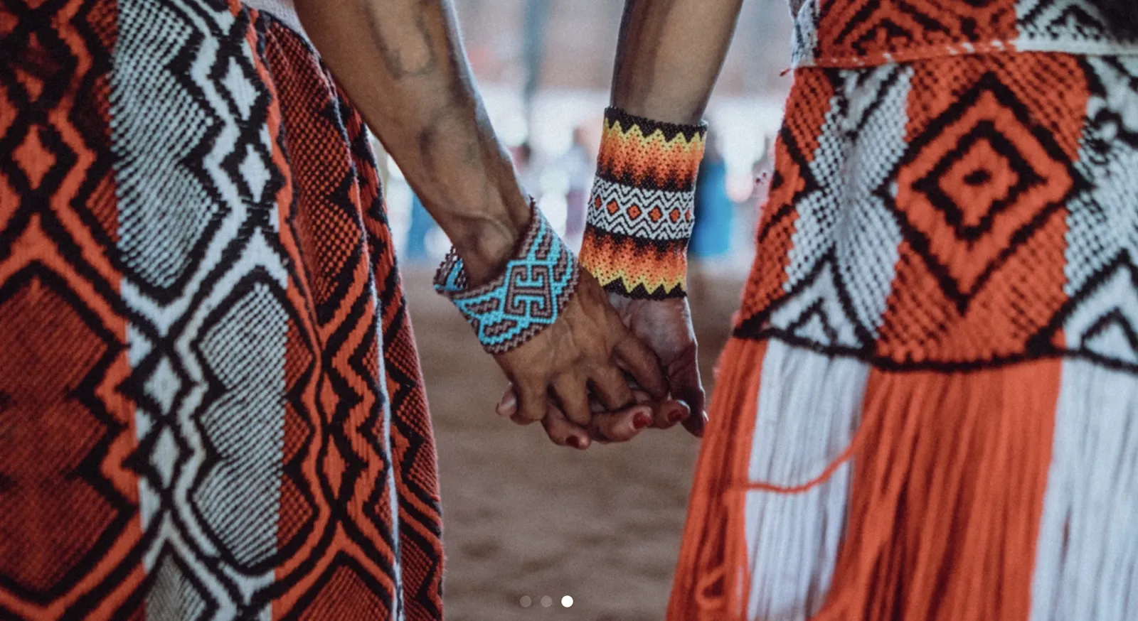 Joined hands over woven Huni Kuin textiles